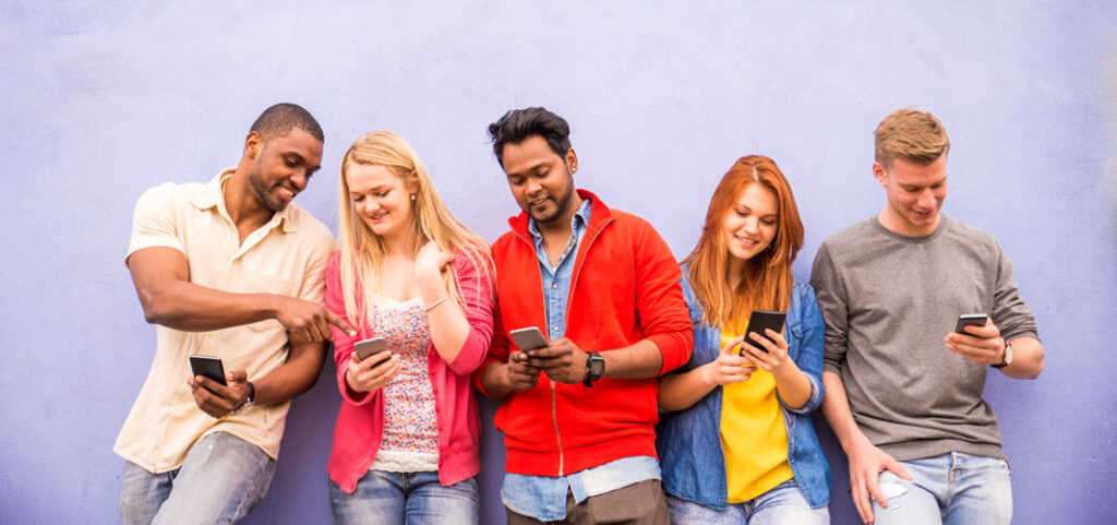 Group of young adults using their mobile phones.