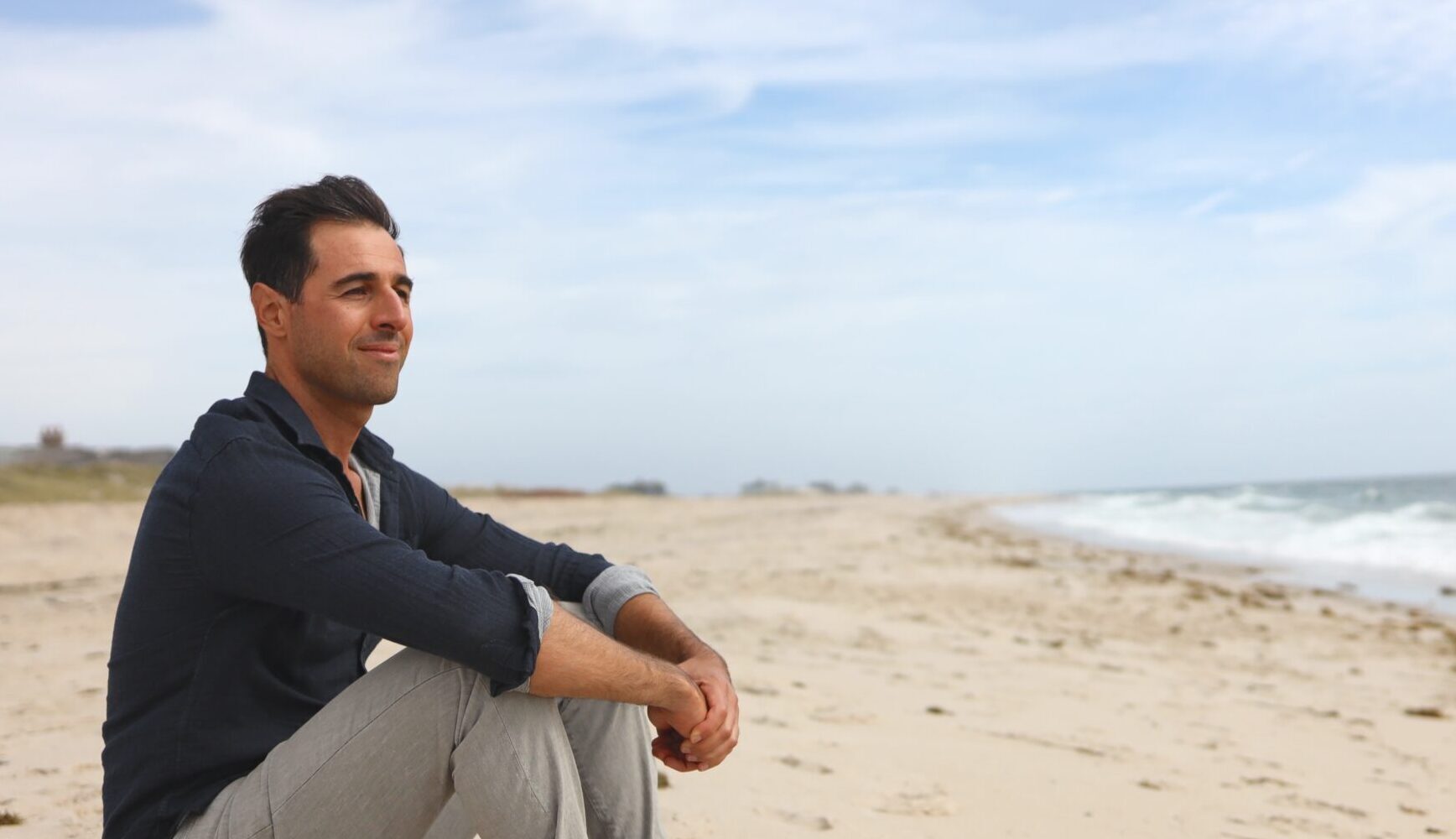 Ben sitting on a beach